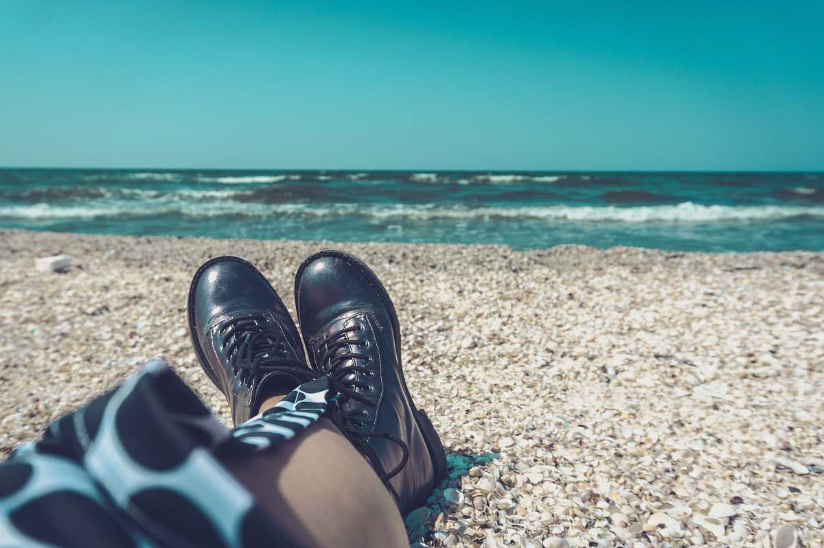 boot person wearing pair of black leather shoes sitting on seashore mamaia