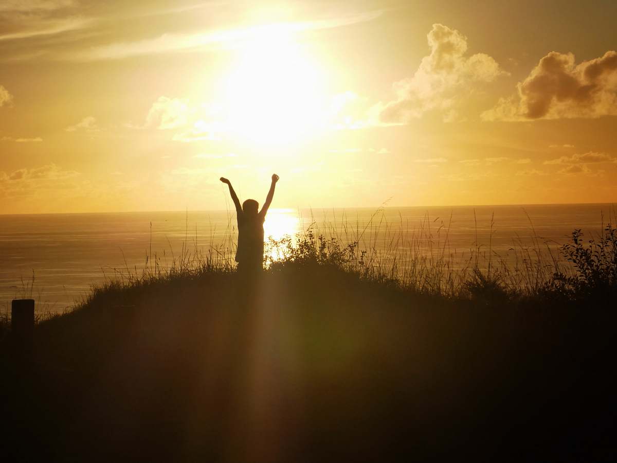 flare silhouette photography unknown person raising hands outdoors light