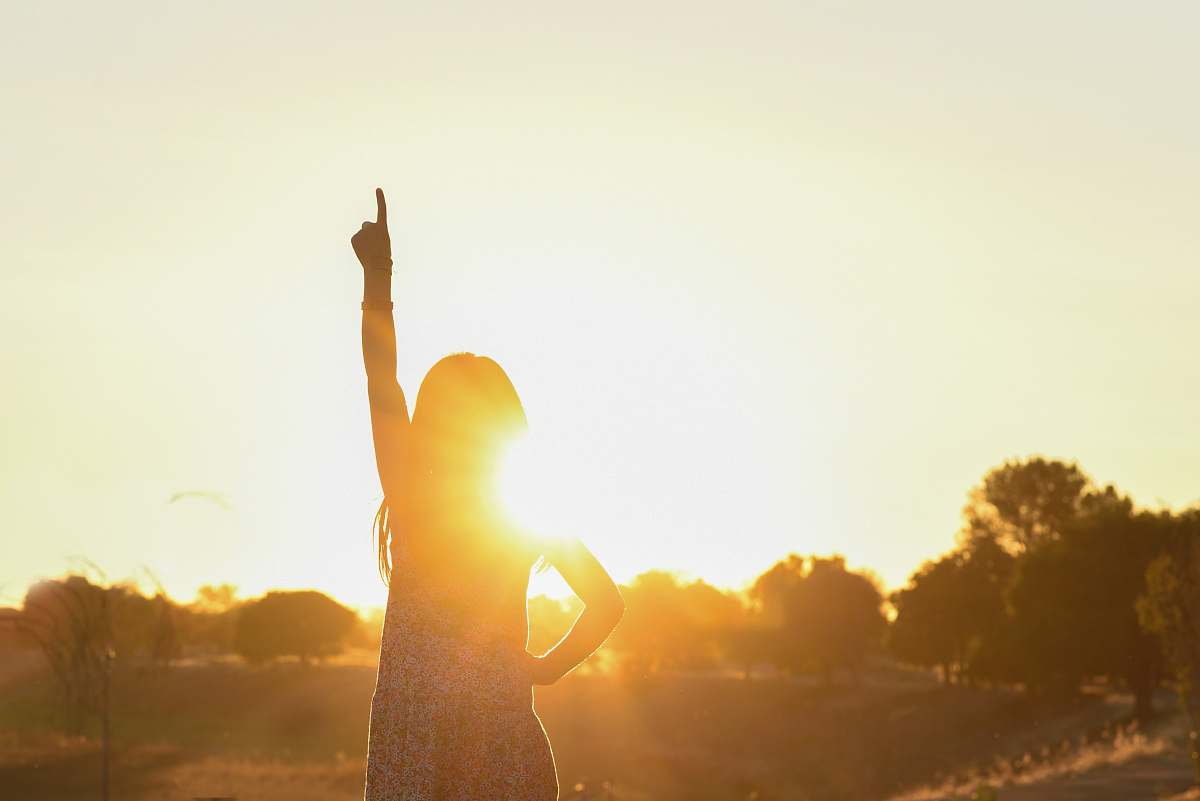 flare woman pointing on ttop near tree light
