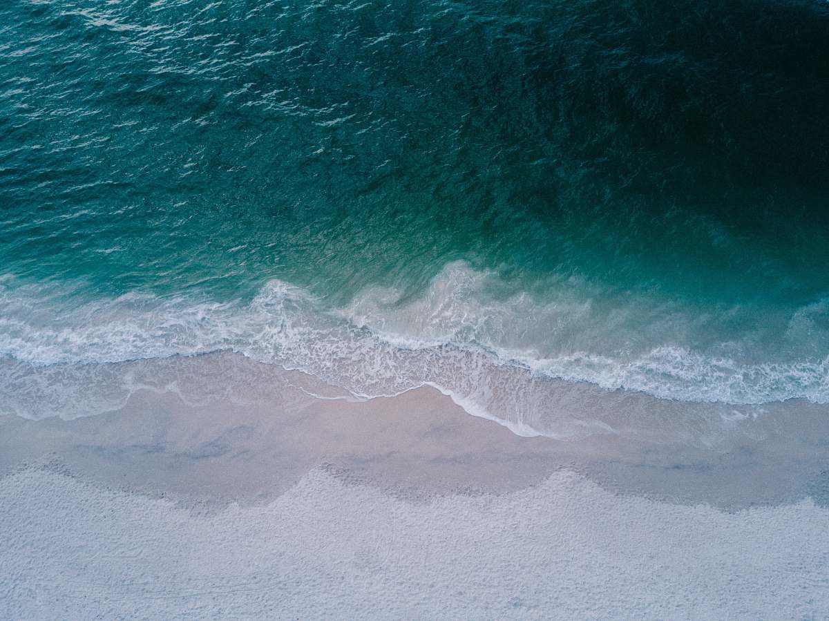 ocean body of water beside sand sea
