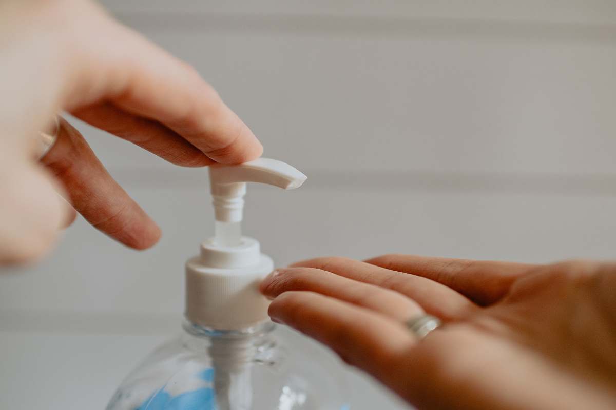 human person holding white plastic pump bottle health