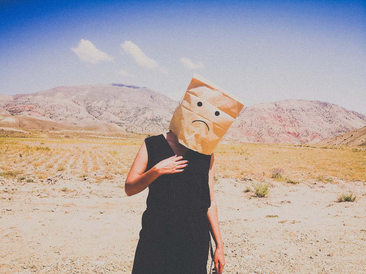 outdoors woman in black dress holding brown paper bag soil