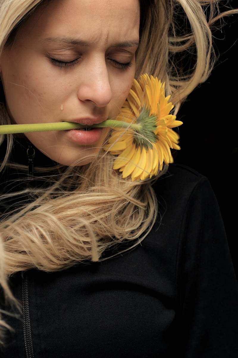 human woman in black shirt with yellow hair tear