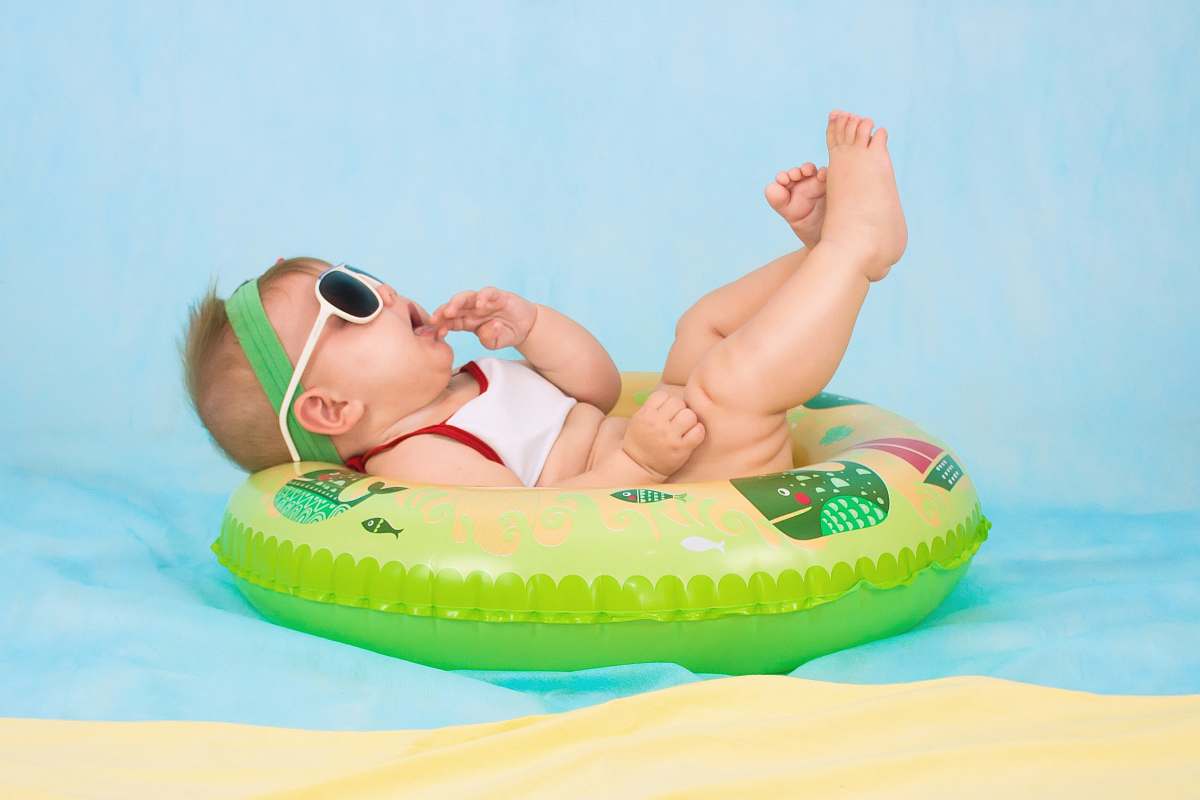 human baby lying on inflatable ring person