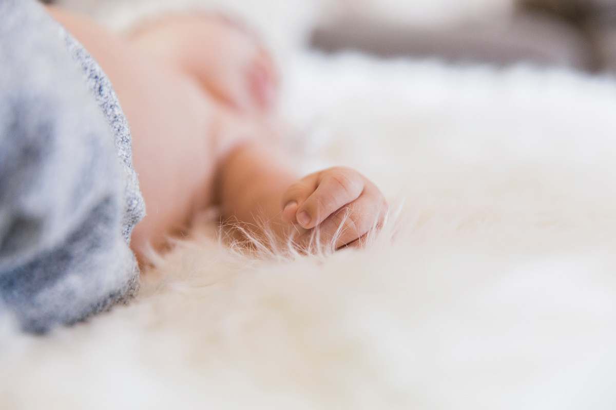 human baby lying on white fabric newborn