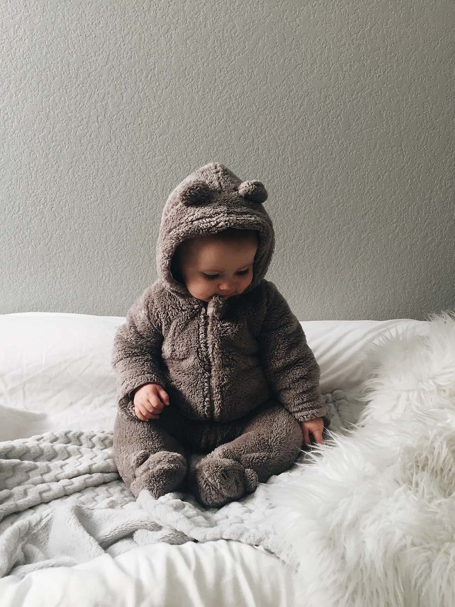 human baby seating on white textile person