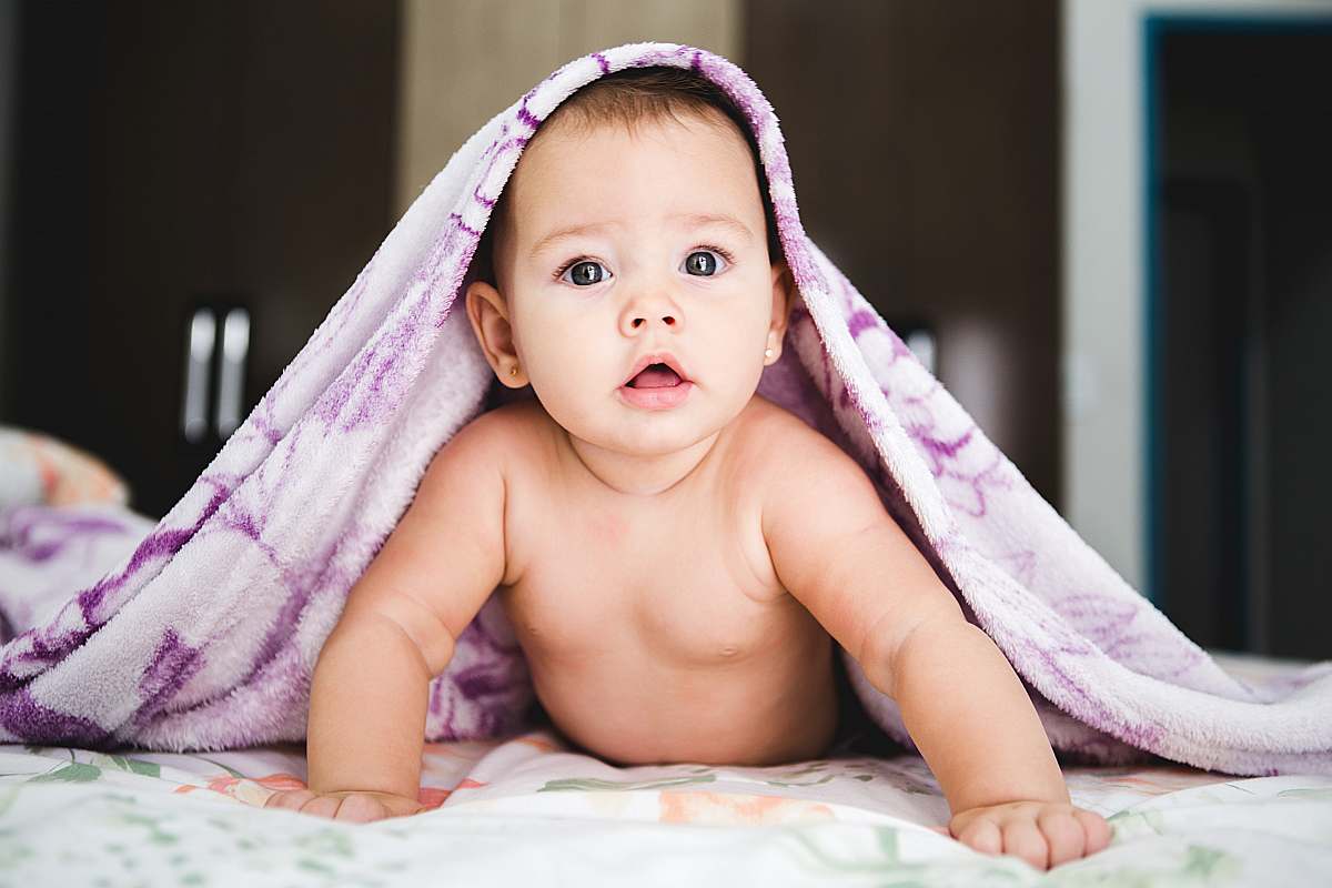 human baby under purple blanket person