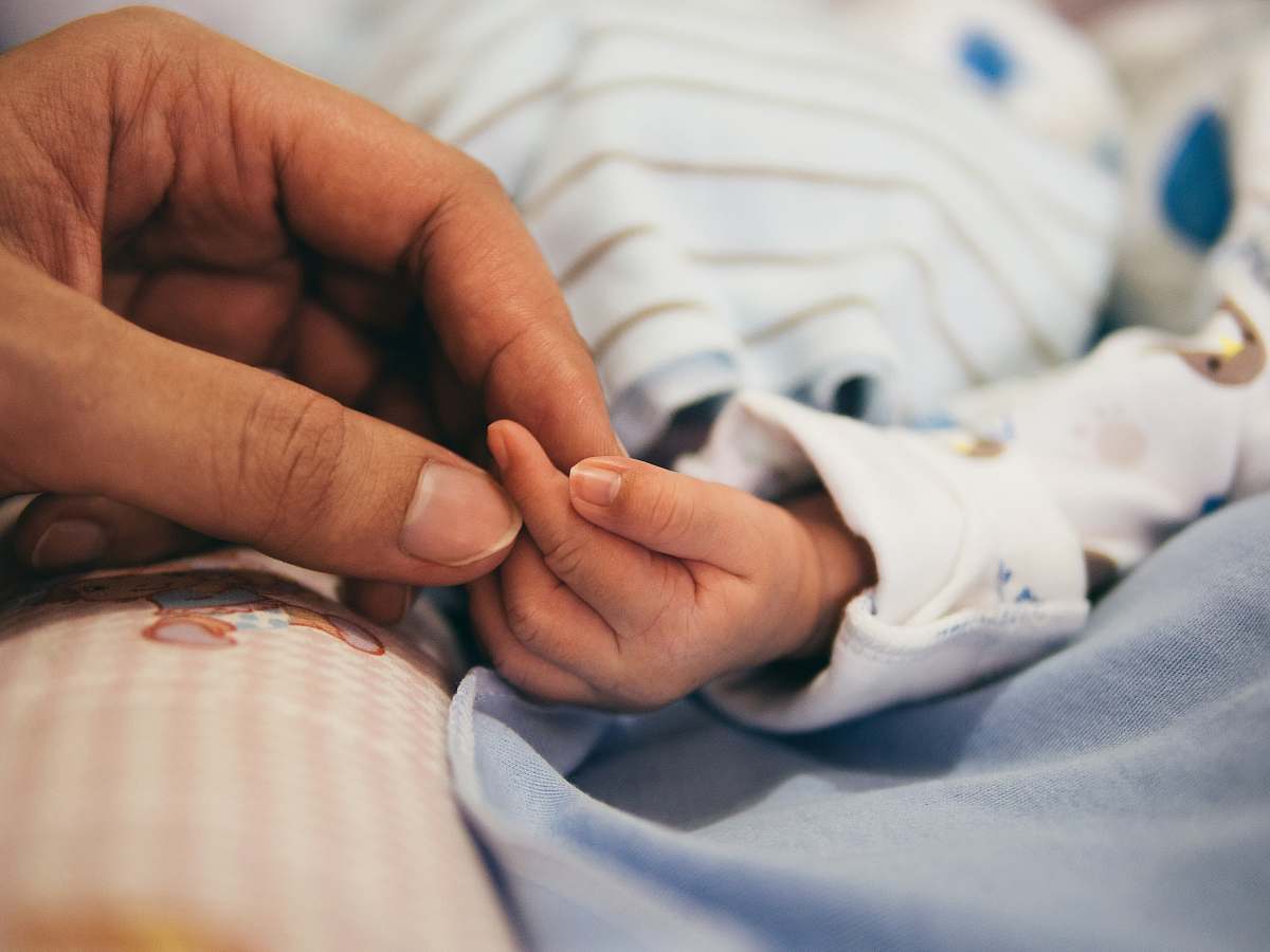 kid person holding baby's index finger hands