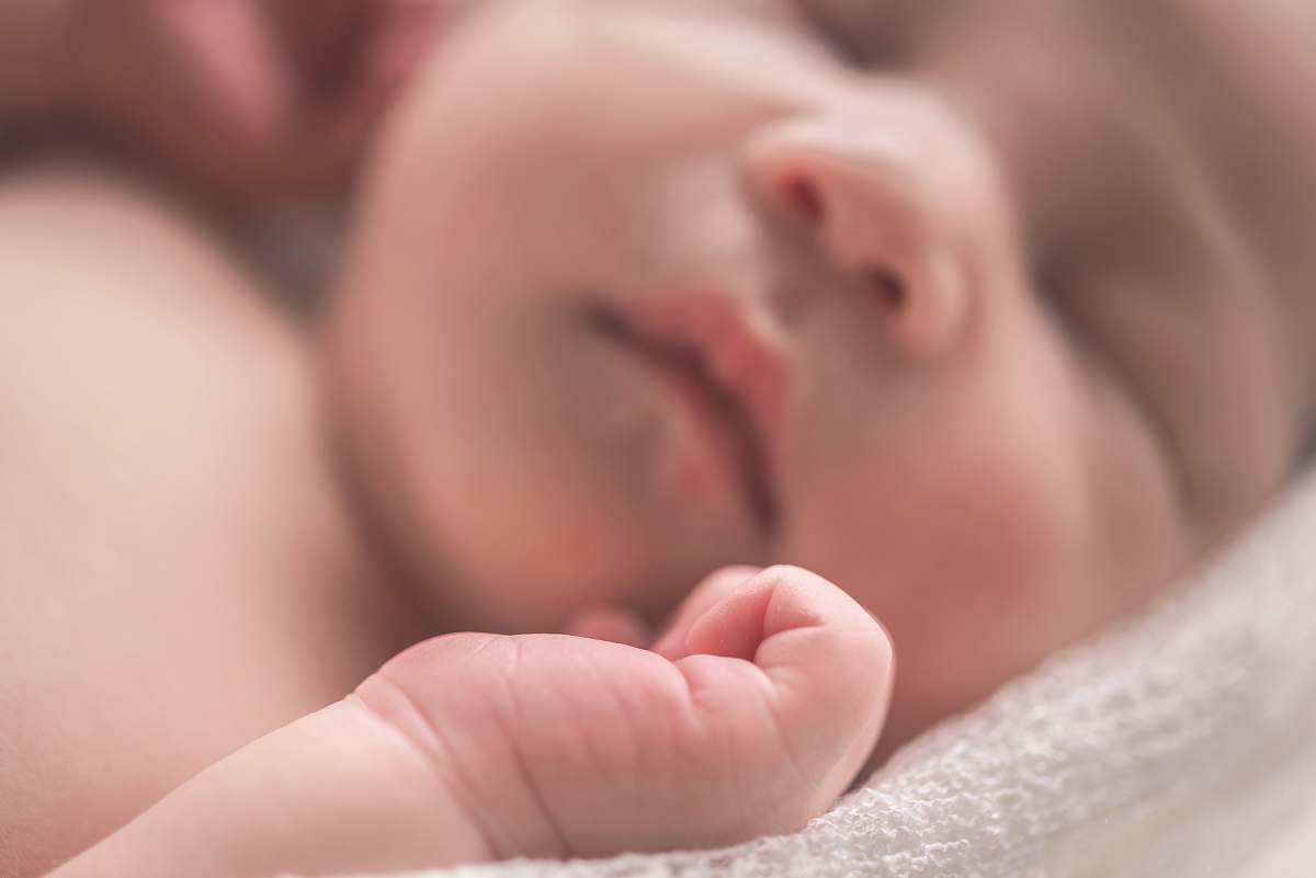 human sleeping baby on white textile newborn