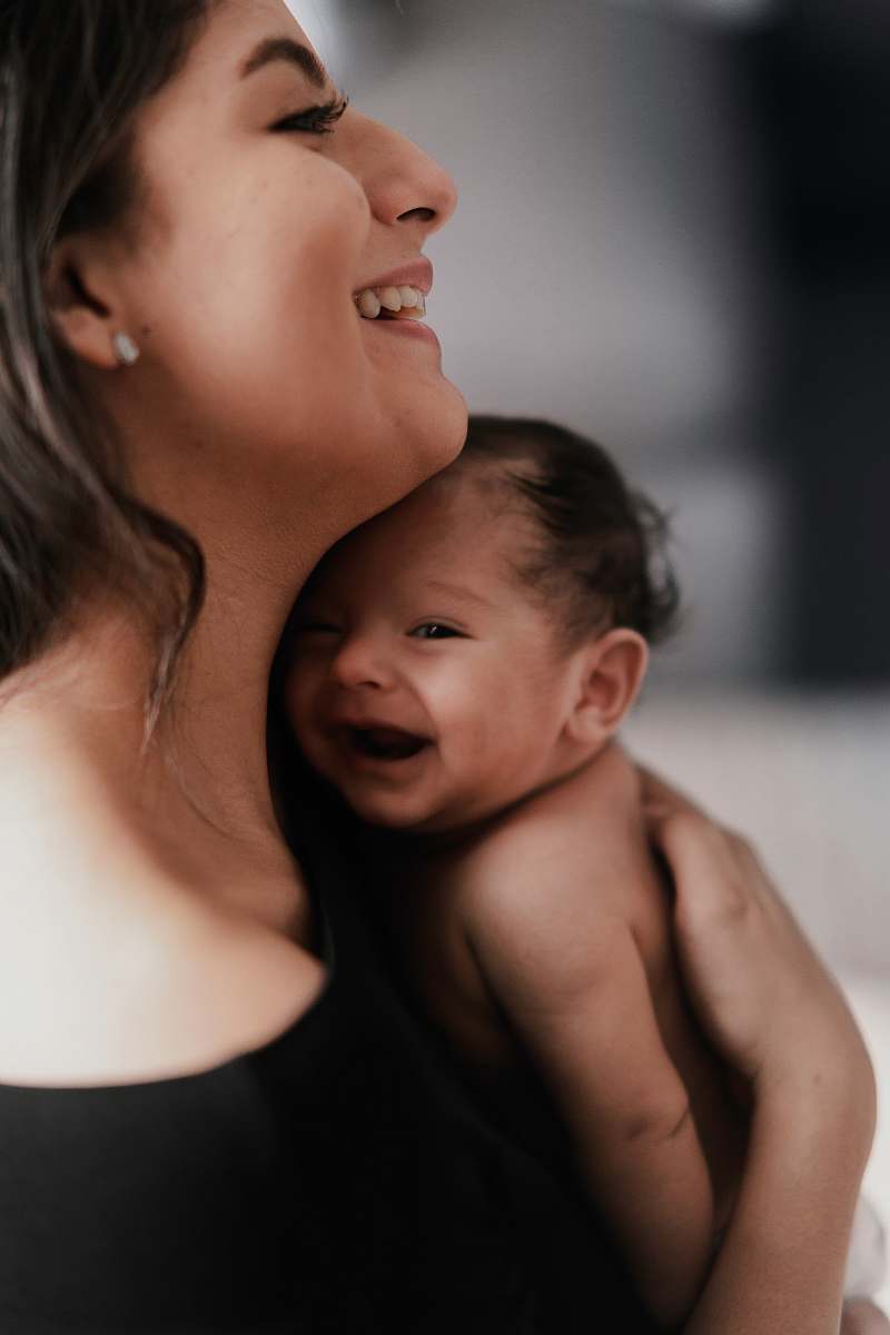 person woman carrying smiling baby newborn