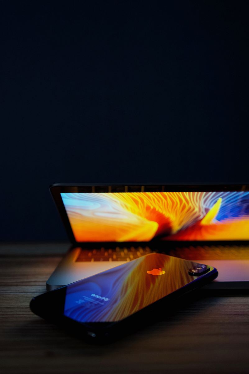 black iPhone on top of laptop computer turned-on