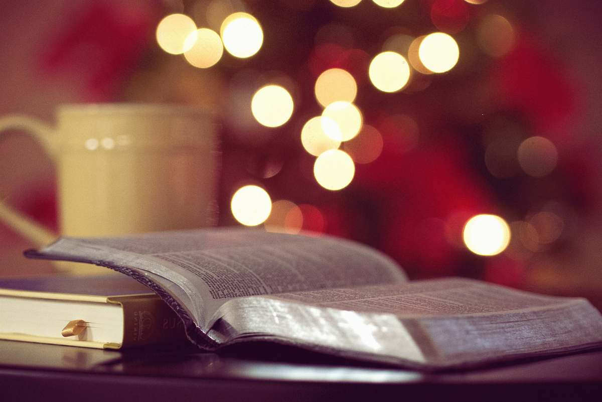 bible bokeh photography of book page near yellow ceramic mug book