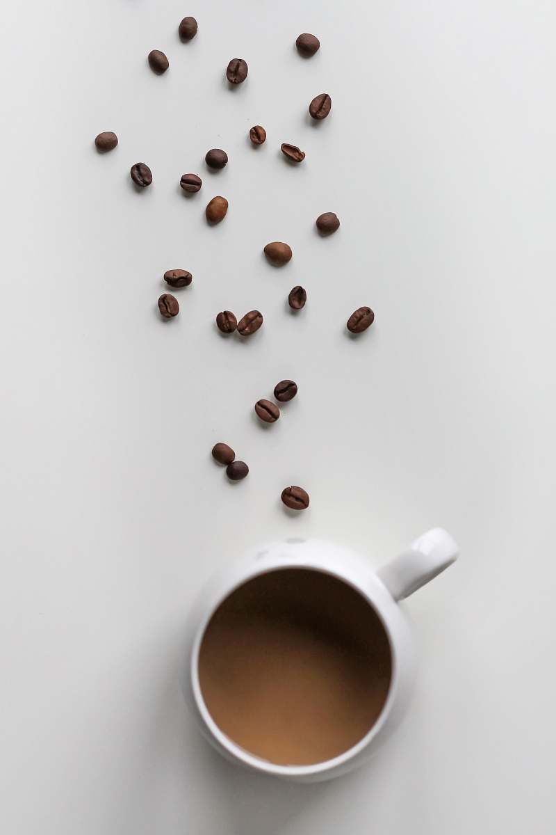 cup coffee beans and coffee filled mug coffee cup