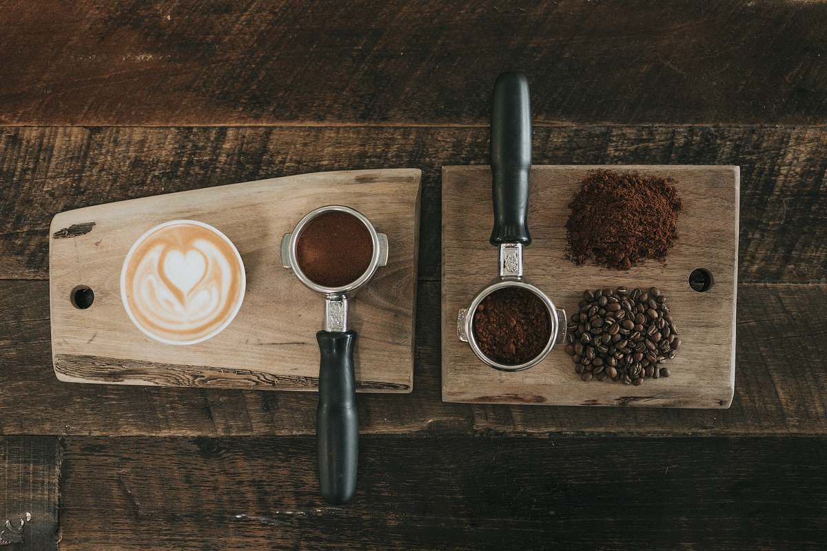 nature coffee beans beside coffee powder on brown wooden board countryside