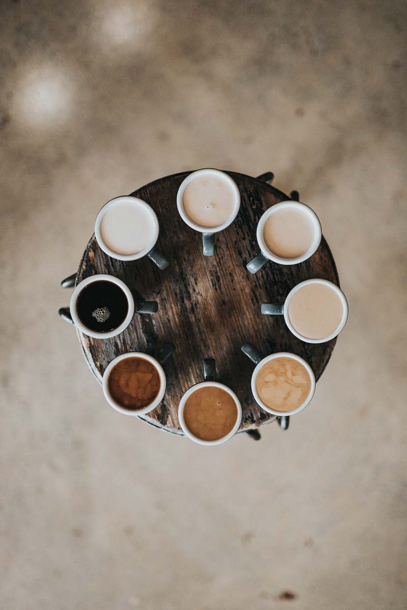 coffee flat lay photography of eight coffee latte in mugs on round table drink