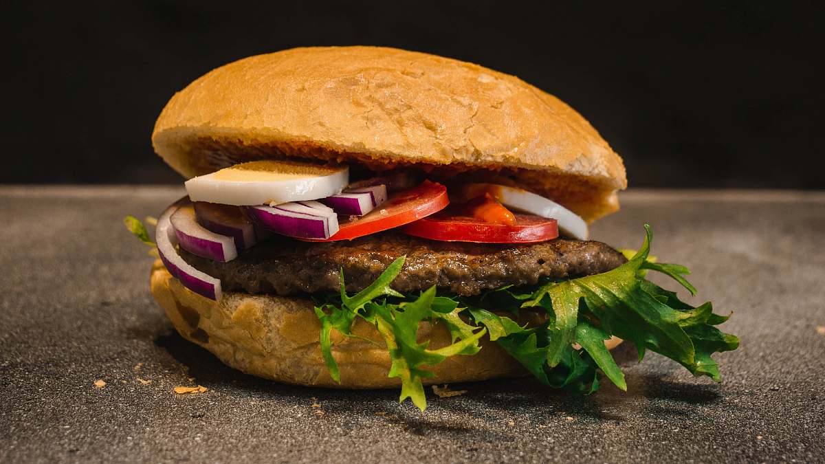 plant burger with potty, tomato, and onion burger