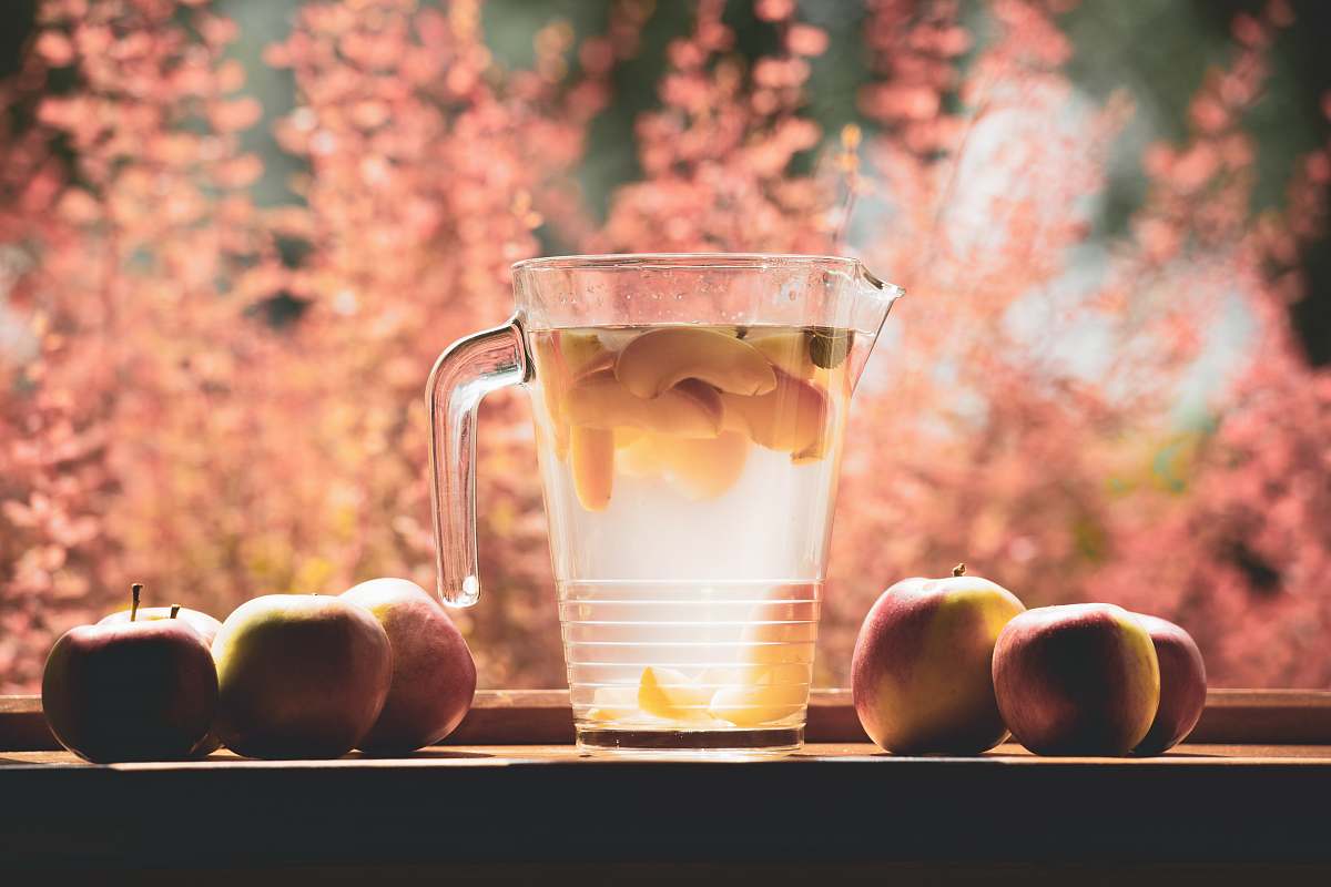 fruit clear glass pitcher filled with clear liquid selective focus photography apple