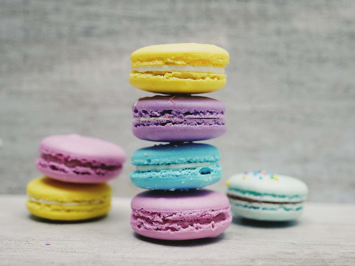 colorful four macarons balancing near two and one macarons colour