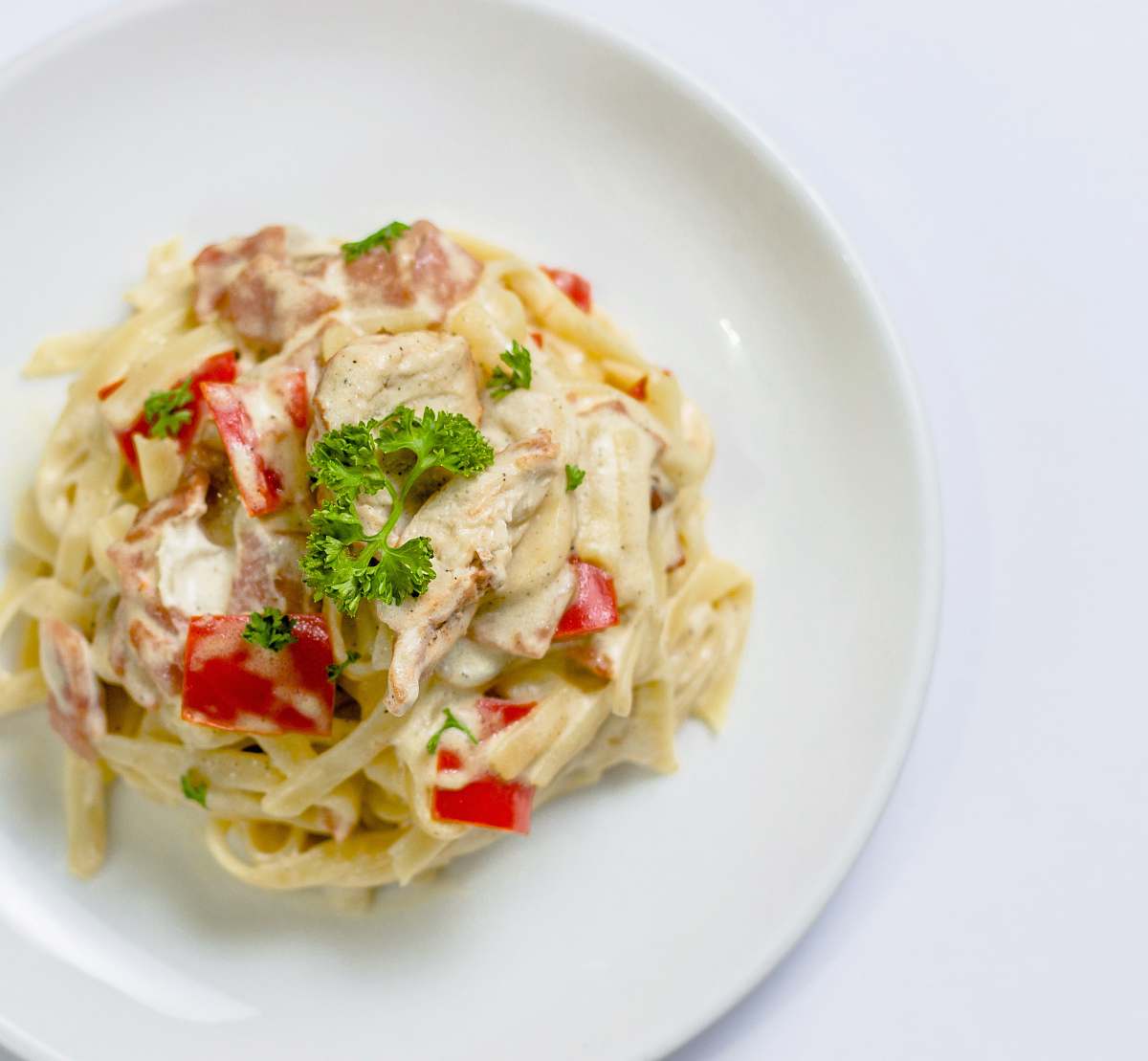 meal plate of white pasta with red bell pepper dish