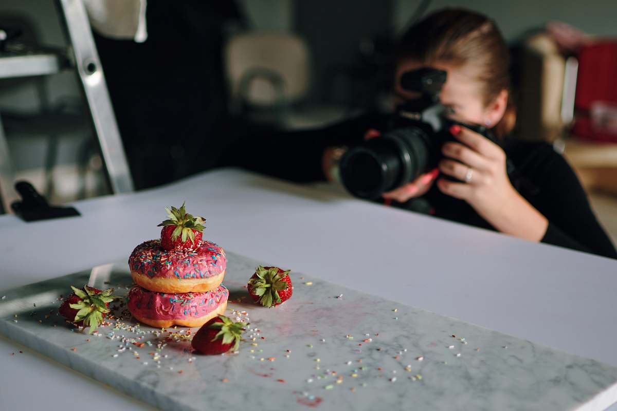 human woman taking photo of donuts person