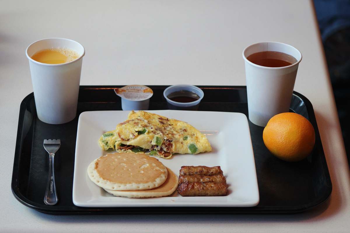 food egg omelet with sausage, pancake and coffee on tray citrus fruit