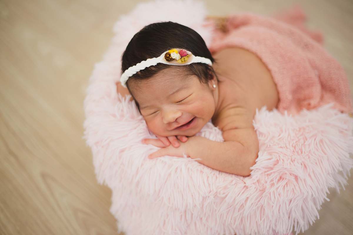 baby baby laying on pink bed newborn
