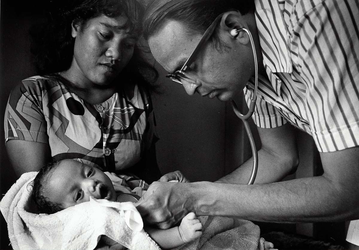 person doctor checking baby black-and-white