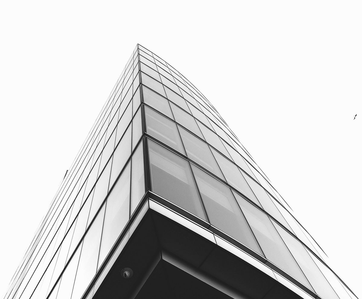 low angle photography of glass building under cloudy sky