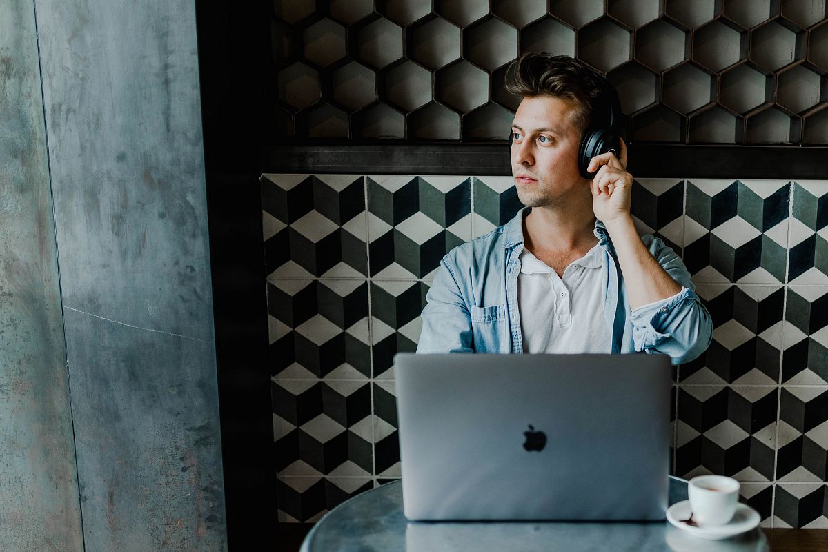 man sitting in front of silver MacBook