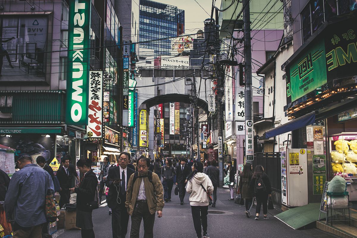 people walking beside gray building during daytime