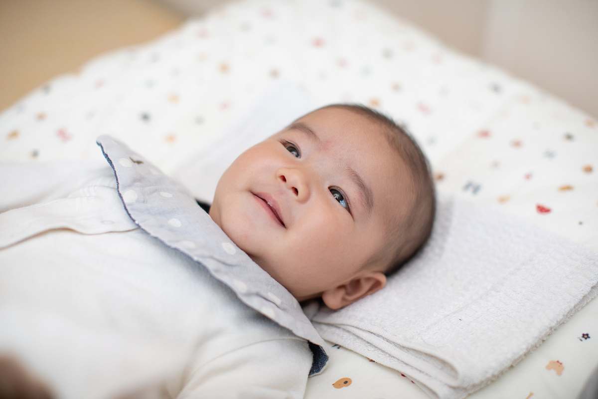 baby baby wearing white shirt lying on bed newborn