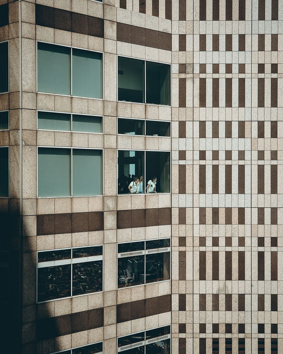three persons at building window