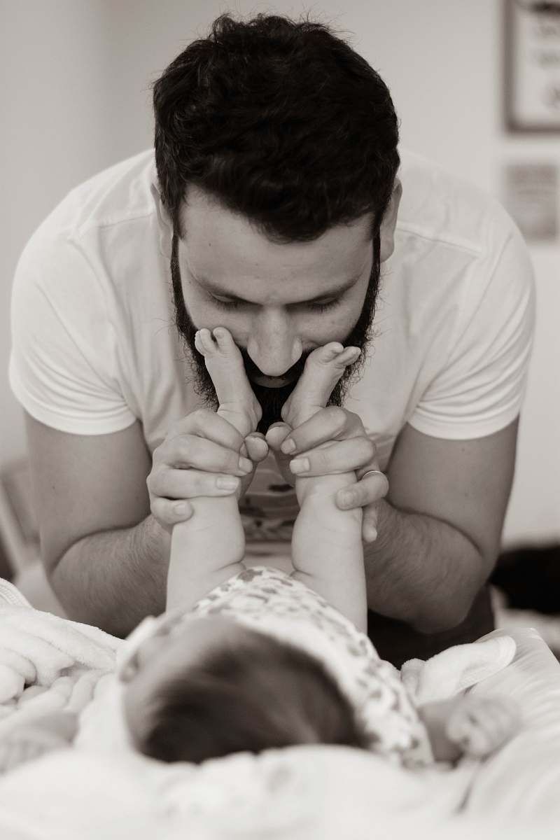 human grayscale photography of man playing with baby person