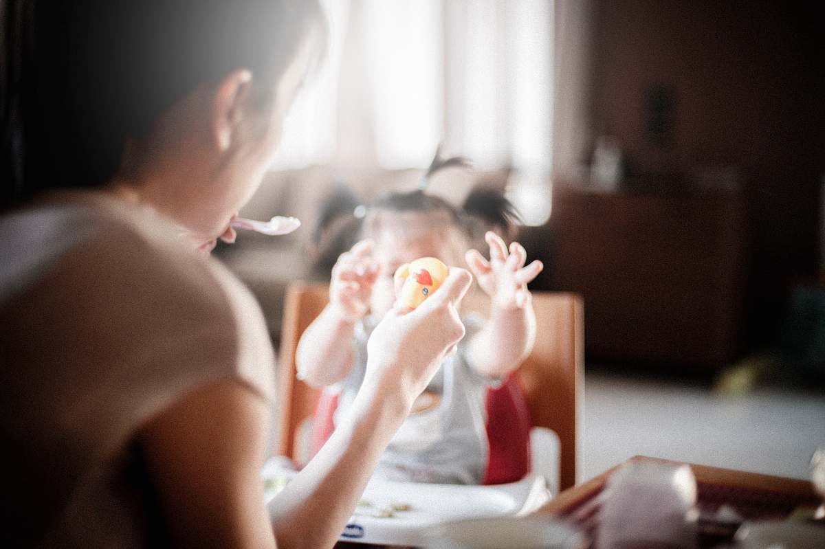 child selective focus photography of woman feeding baby mother