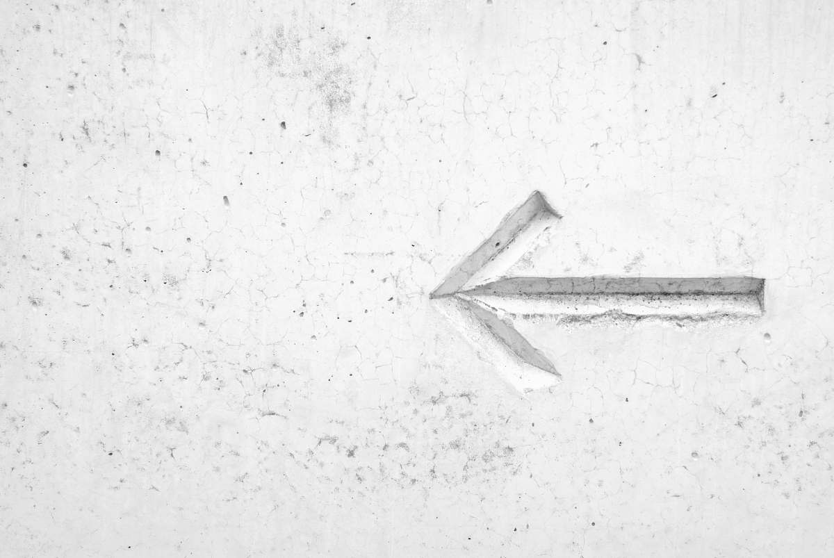 grey right arrow sign on wall white