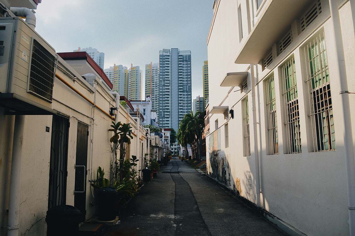 city gray concrete road in between buildings during daytime road