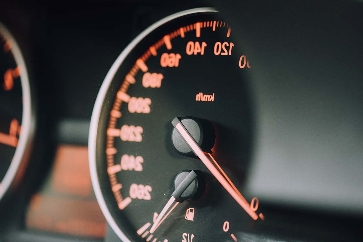 dashboard closeup photo of black analog speedometer closeup