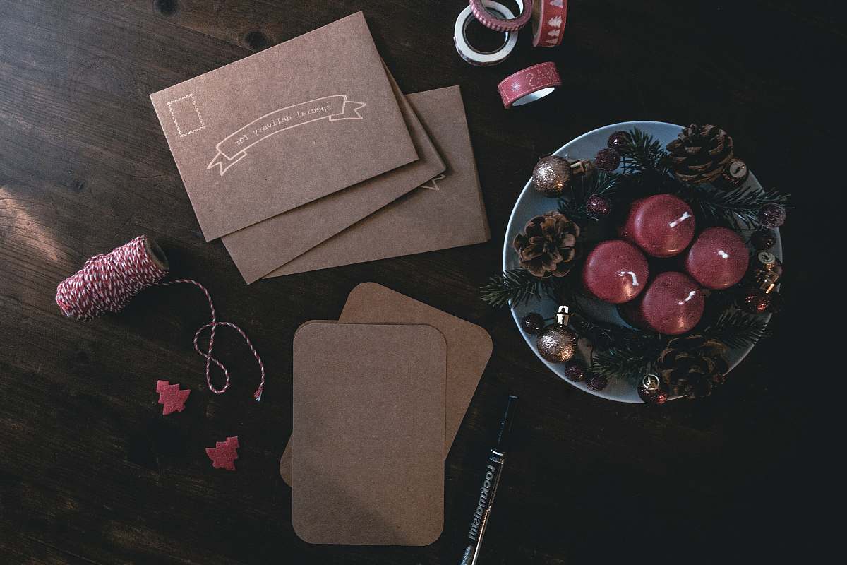 plant four maroon votive candles on teal ceramic plate surrounded by ornaments grapes