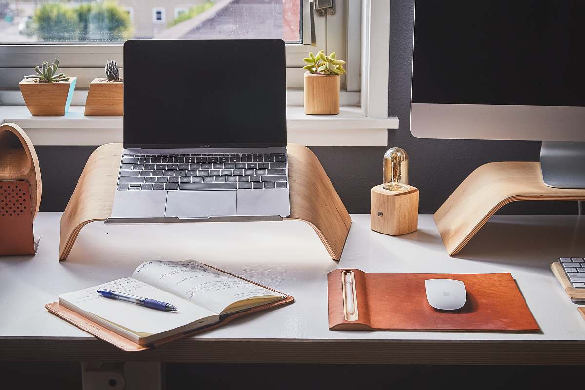 desk black and silver laptop on brown wooden rack laptop