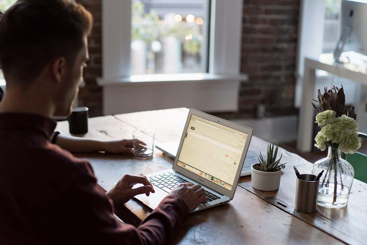 people man operating laptop on top of table laptop