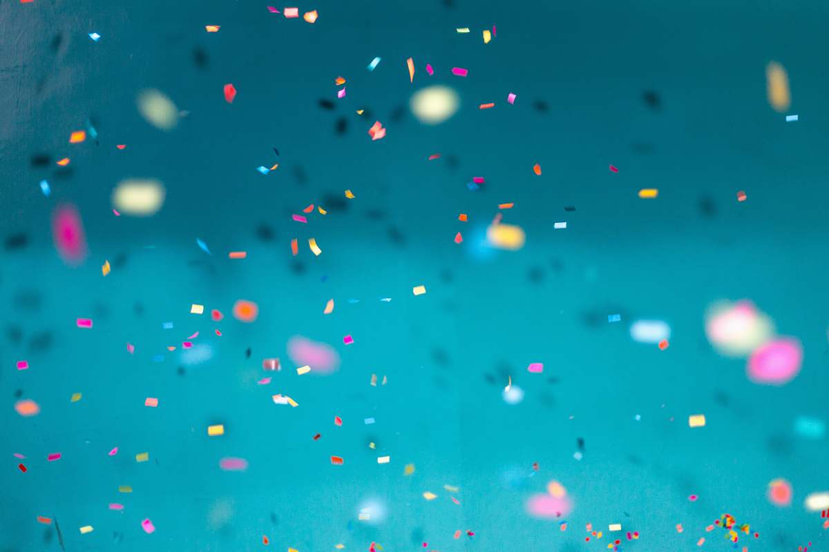 blue selective focus photography of multicolored confetti lot background