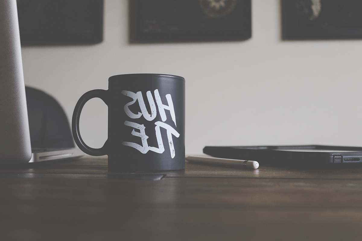 desk black and white Hustle-printed ceramic mug on table hustle