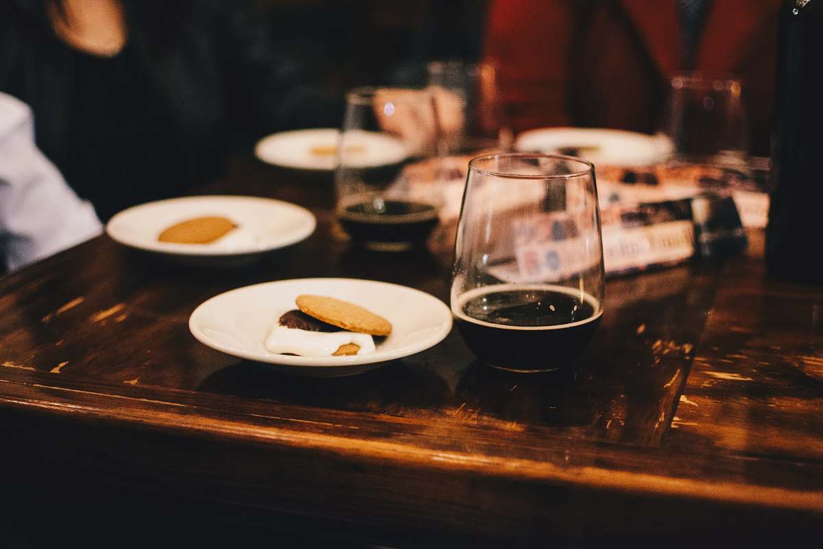dinner selective focus photo of plate with food beside glassware on table beer