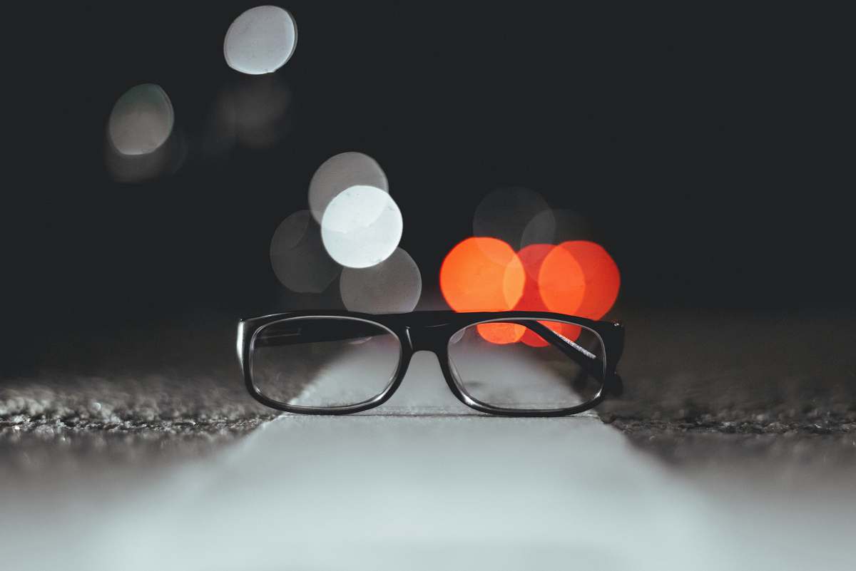 light bokeh light photography of eyeglasses on pavement close up
