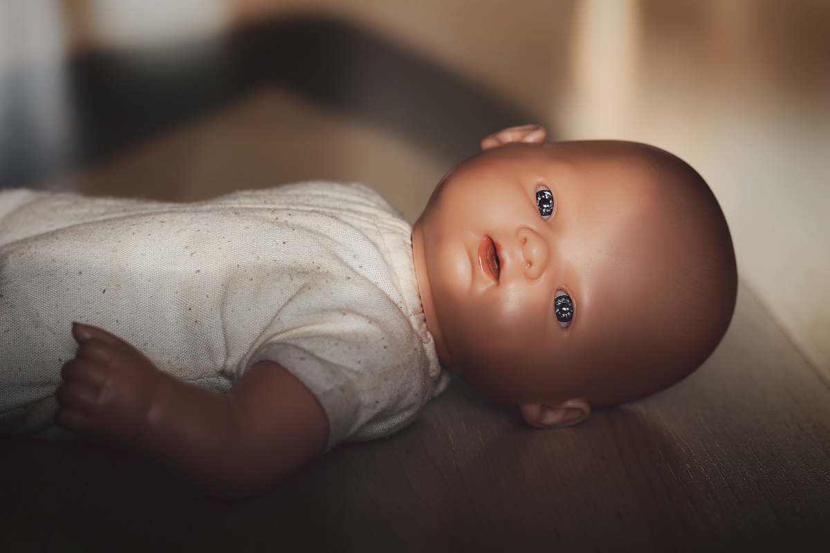 person baby doll on wooden floor face