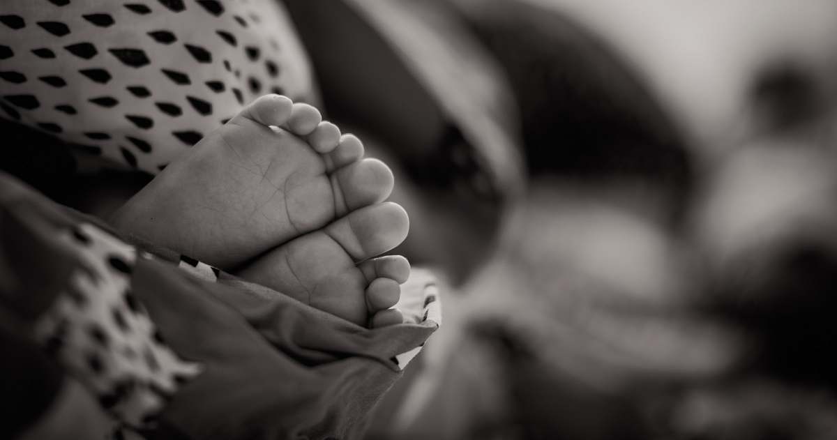 person grayscale photo of baby's feet baby