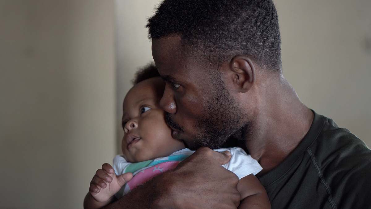 person man carrying baby and kissing face baby