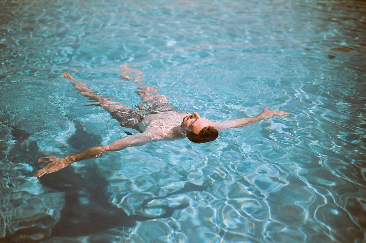 sport man floating on pool water