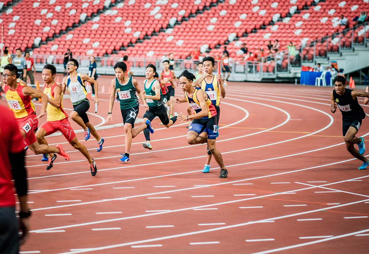 person runners on field running track