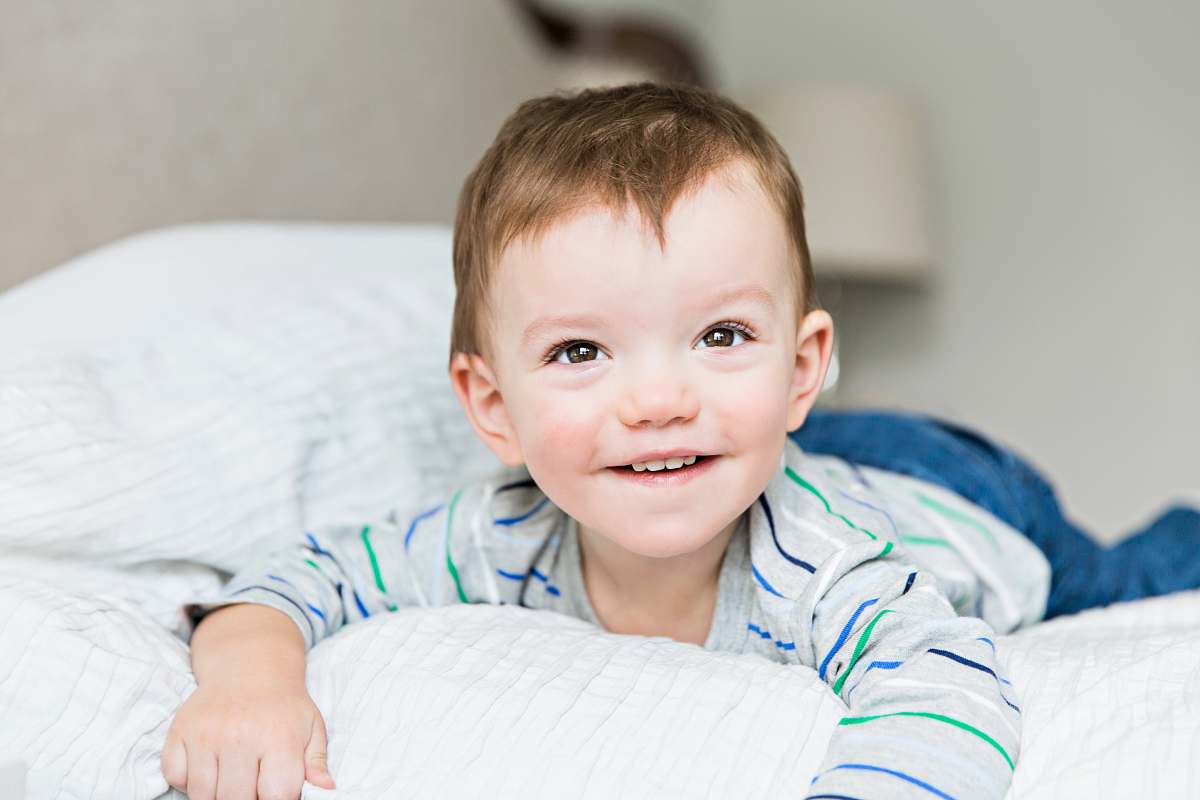 person toddler laying on bed inside room face